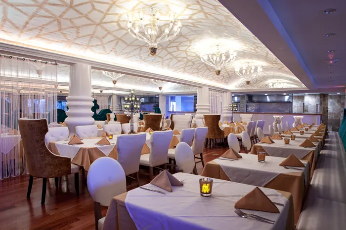 Dining room of the Sand Lake Rd restaurant with chandeliers and white-cloth tables